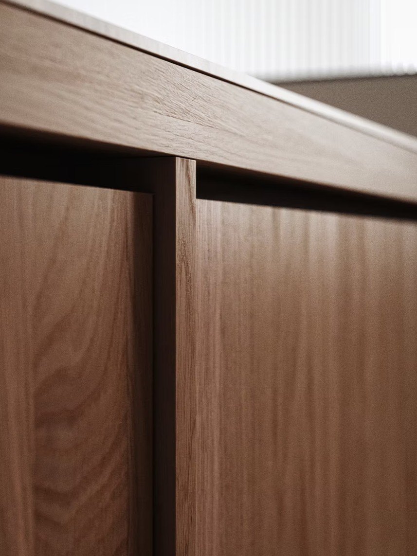 Close-up furniture CGI showing walnut cabinet door, edge detail and dark handle finish